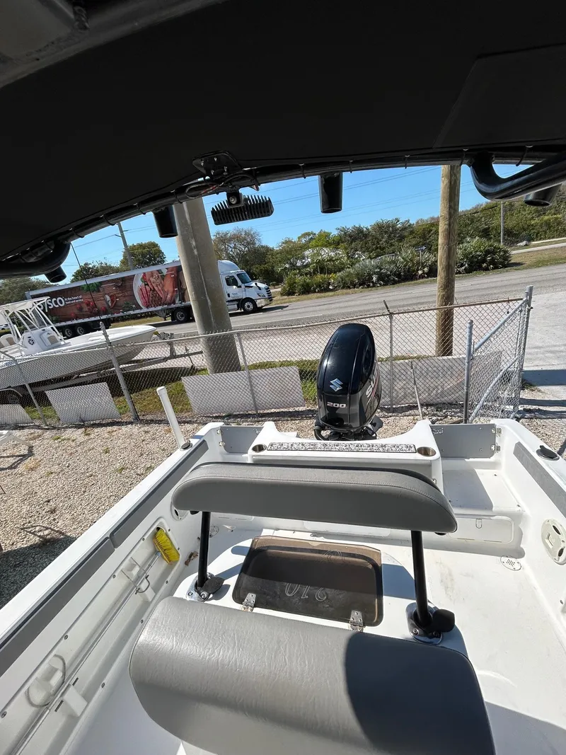 Slide: The Image of 2018 Key Largo 210 boat interior with motor, parked outdoors. - 2