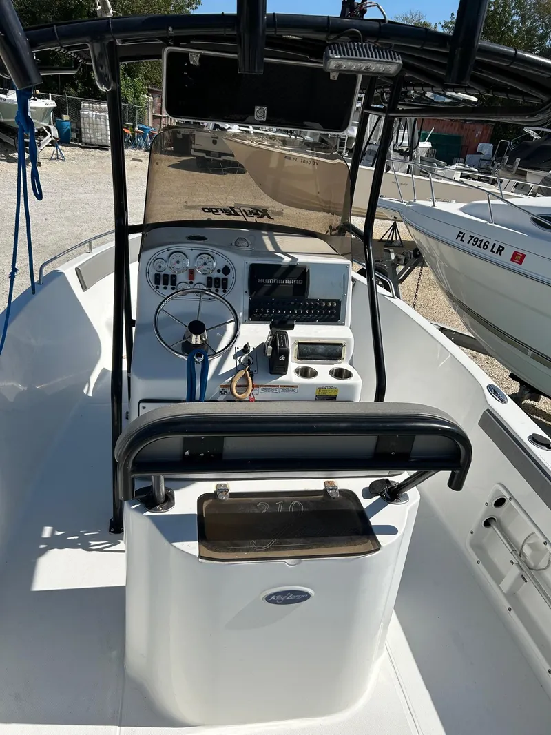 Slide: The Image of 2018 Key Largo 210 boat interior with steering console and navigation equipment. - 3