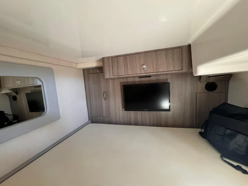 Slide: The Image of 2019 Regal 35 Sport Coupe interior cabin with TV and storage cabinets. - 17