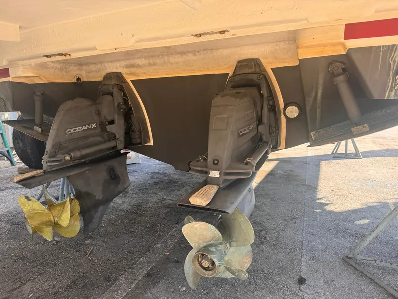 Slide: The Image of 2019 Regal 35 Sport Coupe boat stern with dual outboard motors and propellers. - 23