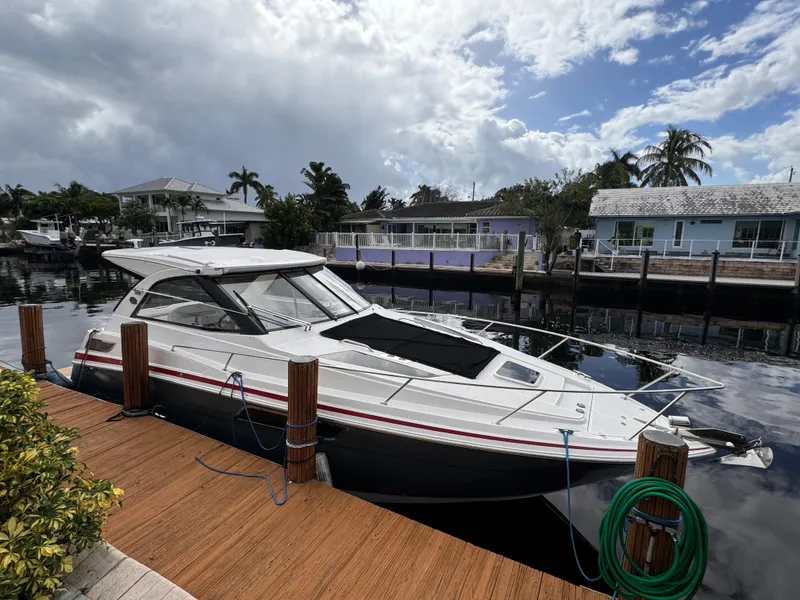 Slide: The Image of 2019 Regal 35 Sport Coupe docked by waterfront homes under a cloudy sky. - 7