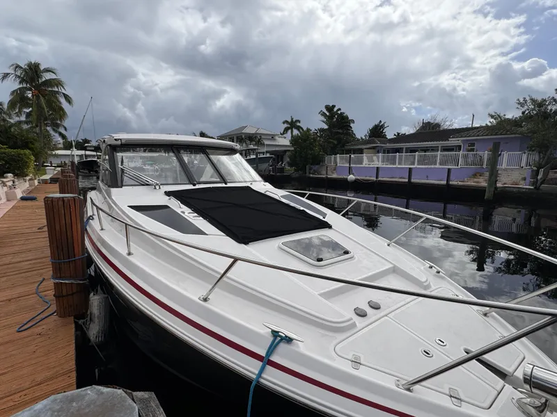 Slide: The Image of 2019 Regal 35 Sport Coupe docked by a waterfront home under cloudy skies. - 8
