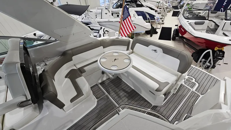Slide: The Image of 2020 Monterey 295 Sport Yacht interior with seating and table, displayed in a showroom. - 13