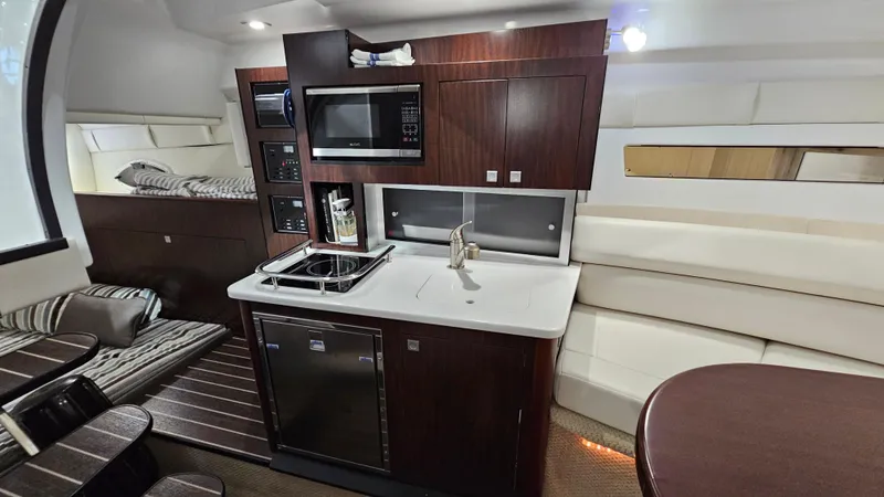 Slide: The Image of Interior of 2020 Monterey 295 Sport Yacht with kitchenette and seating area. - 26