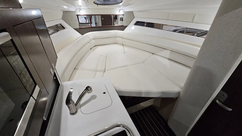 Slide: The Image of 2020 Monterey 295 Sport Yacht interior with white seating and compact kitchenette. - 31