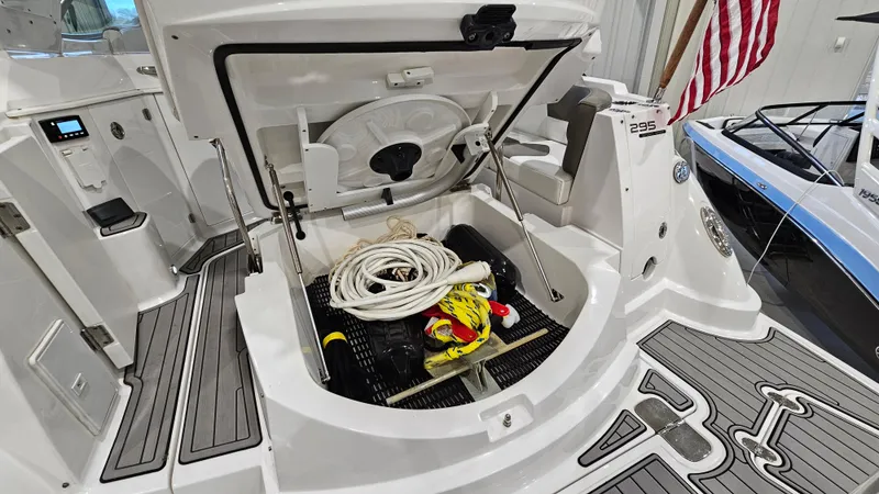 Slide: The Image of 2020 Monterey 295 Sport Yacht storage compartment with equipment and American flag. - 8