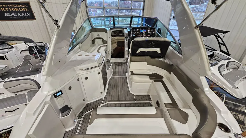 Slide: The Image of 2020 Monterey 295 Sport Yacht interior with seating and helm, displayed in a showroom. - 9