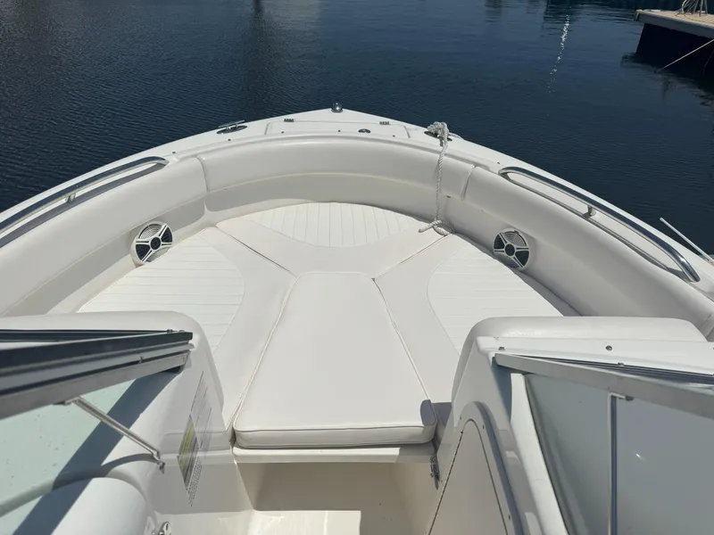 Slide: The Image of 2009 Robalo R227 Dual Console boat with spacious seating, docked on calm water. - 12