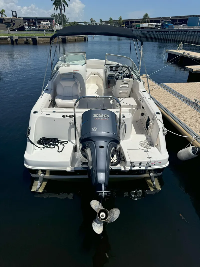 Slide: The Image of 2009 Robalo R227 Dual Console boat docked, featuring a powerful outboard motor. - 3