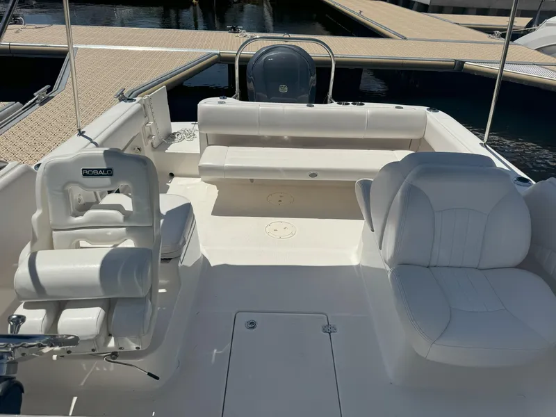 Slide: The Image of 2009 Robalo R227 Dual Console boat interior with white seating at a marina. - 6