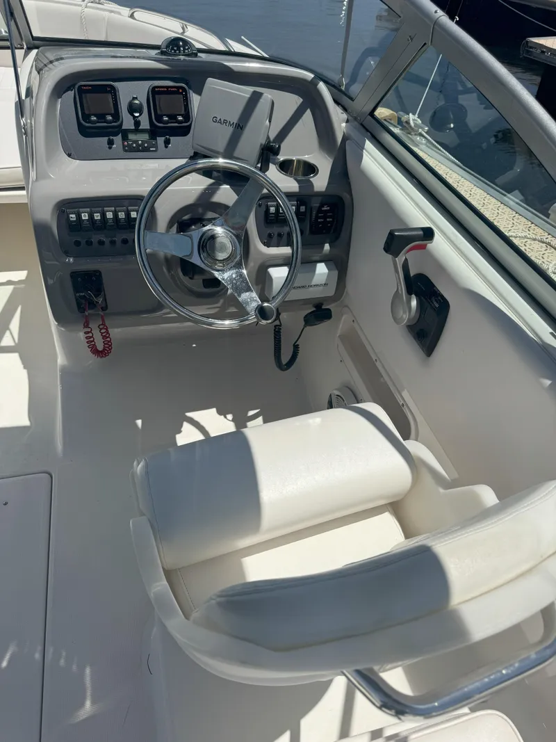 Slide: The Image of 2009 Robalo R227 Dual Console boat cockpit with steering wheel and control panel. - 9