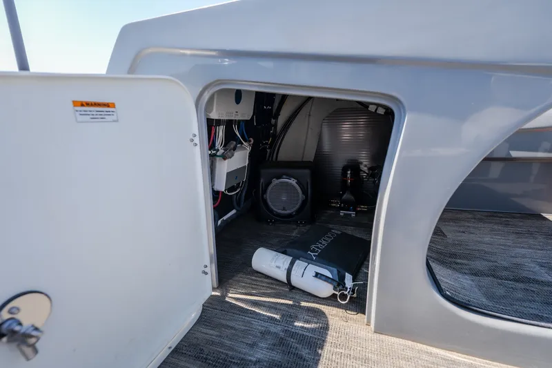 Slide: The Image of Storage compartment of 2021 Godfrey Sanpan 2400 ULC pontoon boat, featuring equipment and safety gear. - 29
