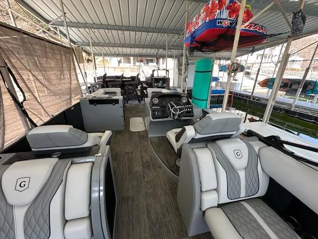 Slide: The Image of 2021 Godfrey Sanpan 2400 ULC pontoon boat interior with luxurious seating and modern dashboard. - 2