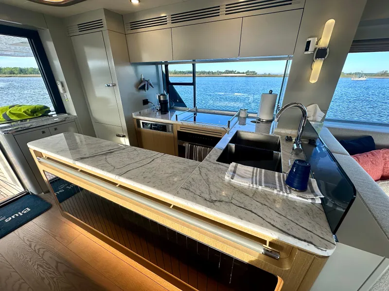 Slide: The Image of Luxurious 2024 Sirena 68 yacht kitchen with marble countertops and scenic ocean view. - 13