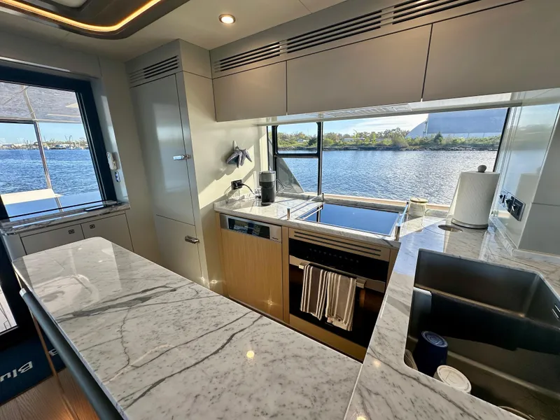 Slide: The Image of Luxurious kitchen interior of 2024 Sirena 68 yacht with marble countertops and scenic water view. - 16