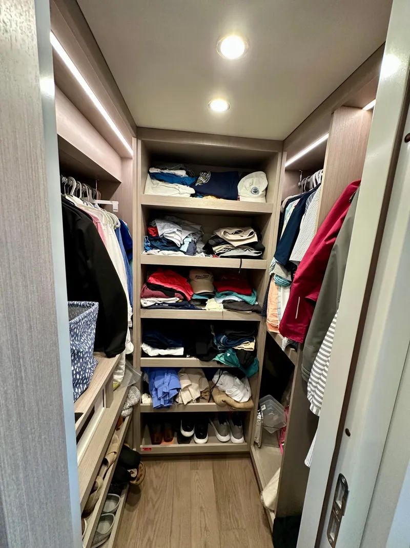 Slide: The Image of Spacious walk-in closet with organized shelves and hanging clothes in a 2024 Sirena 68 yacht. - 22
