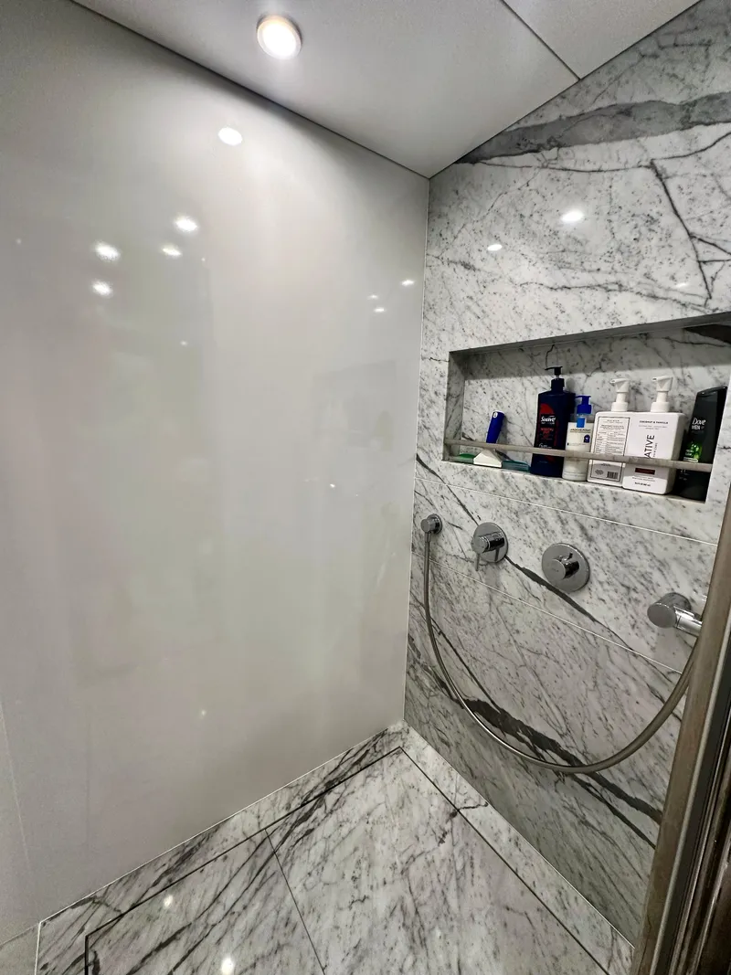 Slide: The Image of Luxurious marble shower in 2024 Sirena 68 yacht with modern fixtures and recessed shelf. - 30