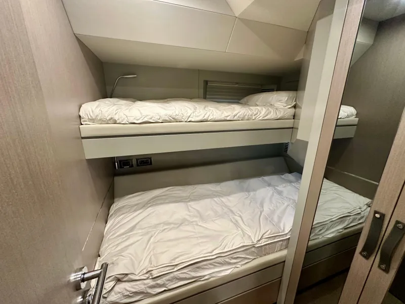 Slide: The Image of Bunk beds in the 2024 Sirena 68 yacht cabin, featuring modern design and cozy bedding. - 37
