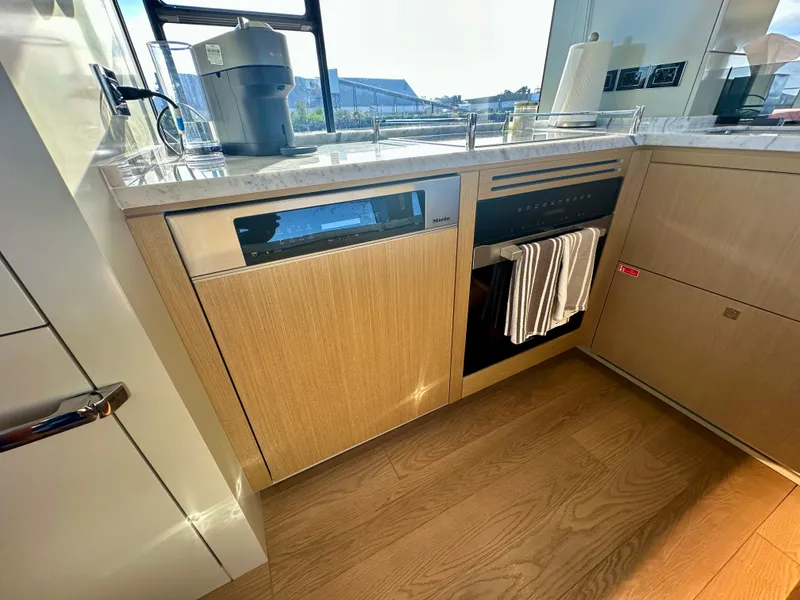 Slide: The Image of 2024 Sirena 68 yacht kitchen with modern appliances and wooden cabinetry. - 8