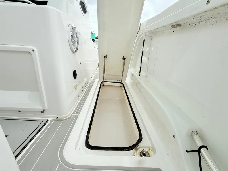 Slide: The Image of 2022 Twin Vee 280 GFX CC boat storage compartment open, showcasing interior space. - 13