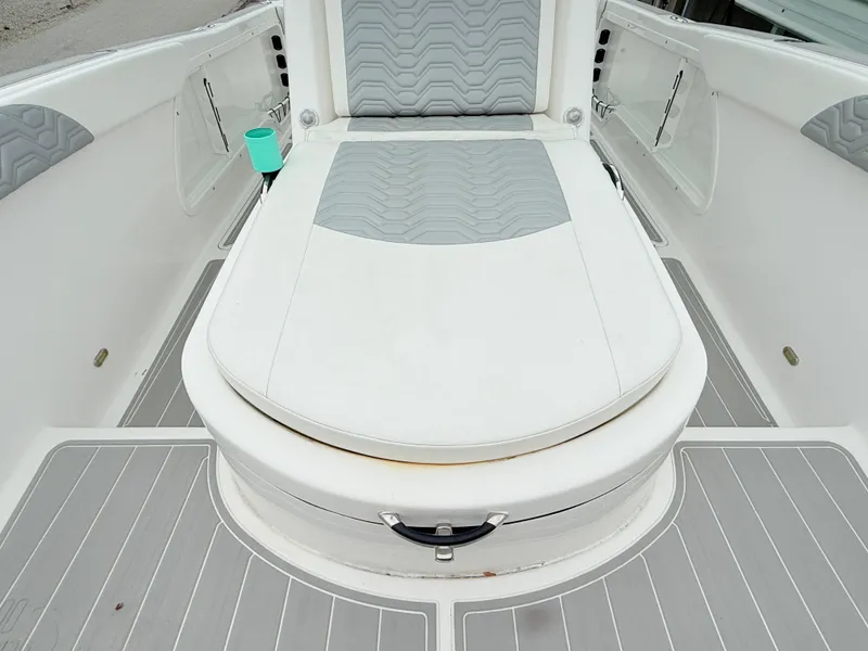 Slide: The Image of 2022 Twin Vee 280 GFX CC boat interior with cushioned seating and storage compartments. - 14