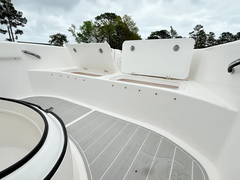 Slide: The Image of 2022 Twin Vee 280 GFX CC boat interior with open storage compartments and gray flooring. - 18