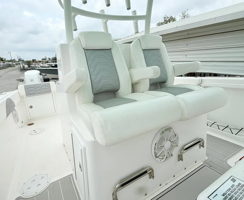 Slide: The Image of 2022 Twin Vee 280 GFX CC boat seats, white and gray, with armrests and speaker. - 19