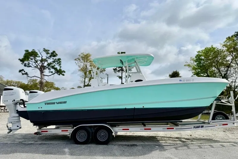 Slide: The Image of 2022 Twin Vee 280 GFX CC boat on trailer, featuring dual Suzuki engines. - 21