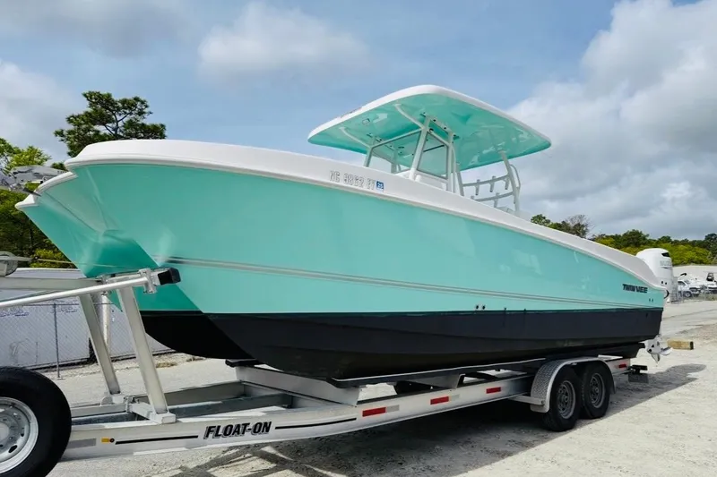 Slide: The Image of 2022 Twin Vee 280 GFX CC boat on trailer, turquoise and white design. - 24