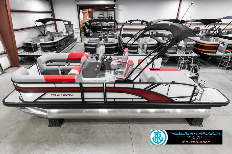 Slide: The Image of 2025 Bennington 21 SSB pontoon boat in showroom, featuring sleek design and red accents. - 1
