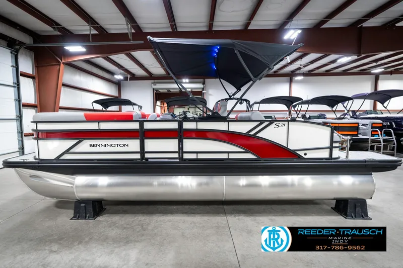 Slide: The Image of 2025 Bennington 21 SSB pontoon boat in showroom, featuring sleek design and modern amenities. - 11