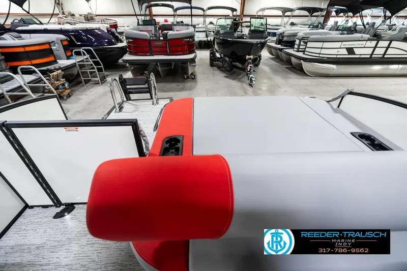 Slide: The Image of 2025 Bennington 21 SSB pontoon boat in showroom with vibrant red seating. - 18