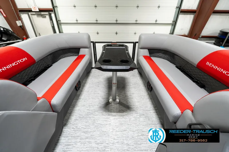 Slide: The Image of 2025 Bennington 21 SSB boat interior with red and gray seating and central table. - 21