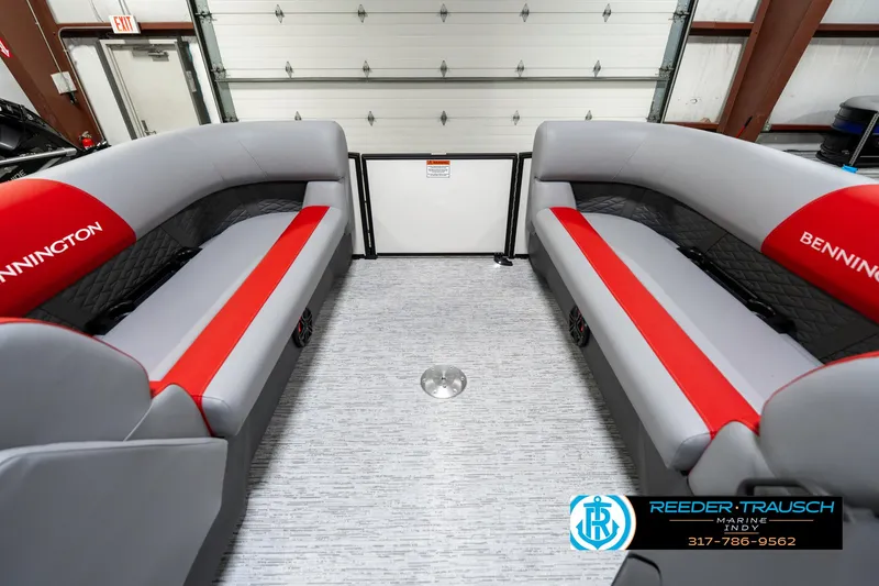 Slide: The Image of 2025 Bennington 21 SSB boat interior with gray and red seating in a garage. - 22