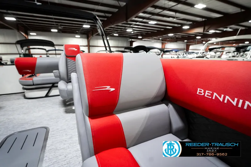 Slide: The Image of 2025 Bennington 21 SSB boat interior with red and gray seating in showroom. - 24