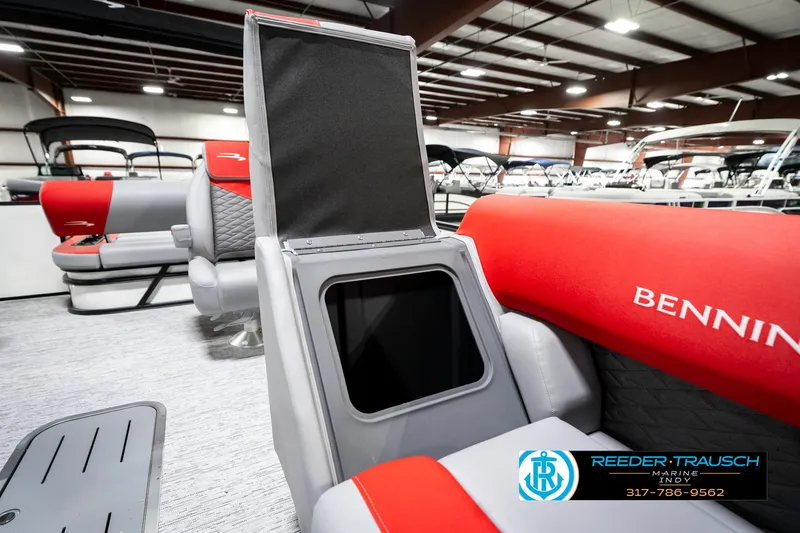 Slide: The Image of 2025 Bennington 21 SSB boat interior with open storage compartment, red and gray seating. - 25