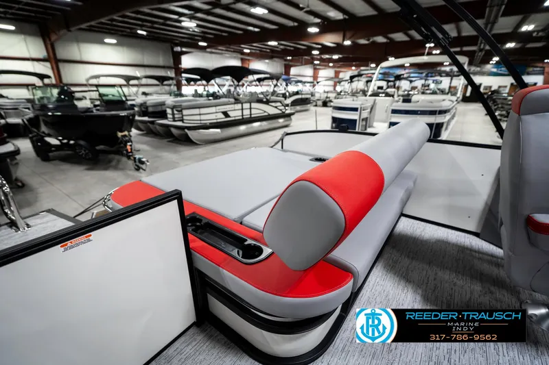 Slide: The Image of 2025 Bennington 21 SSB pontoon boat interior with red and gray seating in showroom. - 26