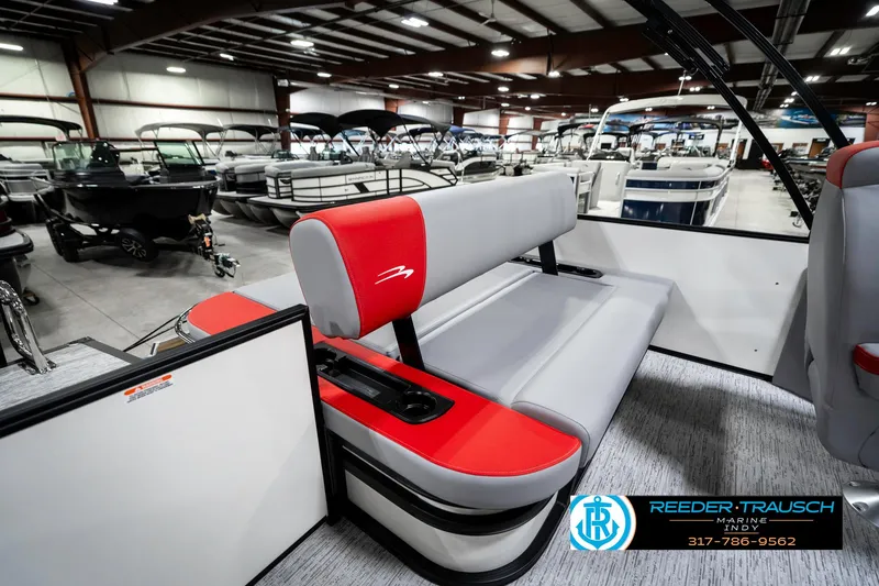 Slide: The Image of 2025 Bennington 21 SSB pontoon boat interior with red and gray seating in showroom. - 28