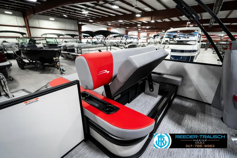 Slide: The Image of 2025 Bennington 21 SSB pontoon boat interior with red and gray seating in showroom. - 29