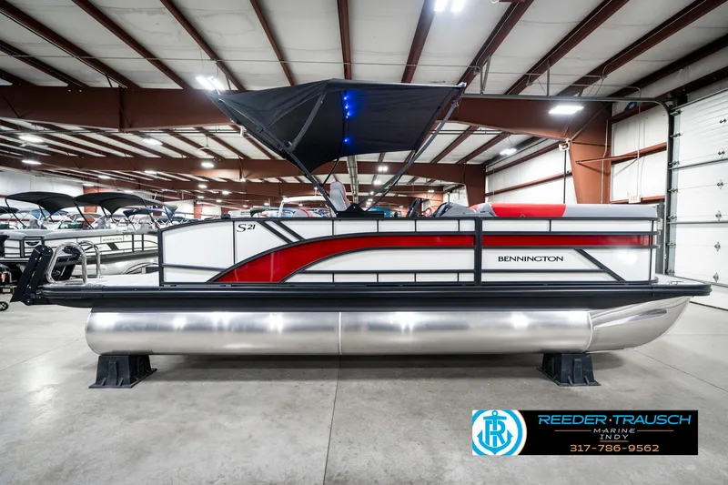 Slide: The Image of 2025 Bennington 21 SSB pontoon boat in showroom, featuring sleek design and modern canopy. - 7