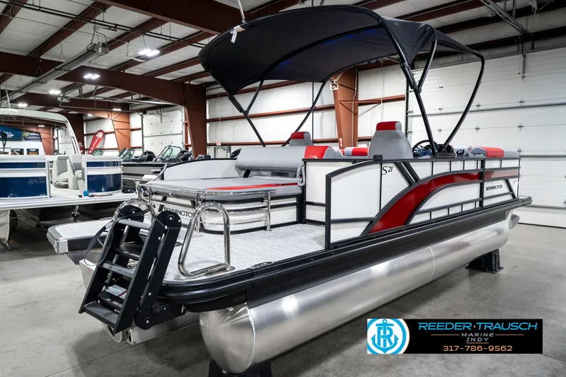 Slide: The Image of 2025 Bennington 21 SSB pontoon boat in showroom, featuring sleek design and canopy. - 8