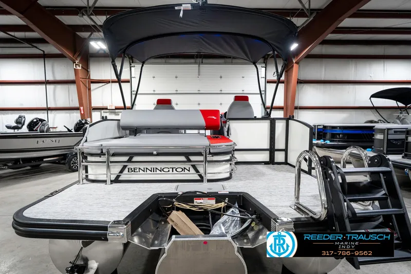 Slide: The Image of 2025 Bennington 21 SSB pontoon boat in showroom with canopy and seating. - 9