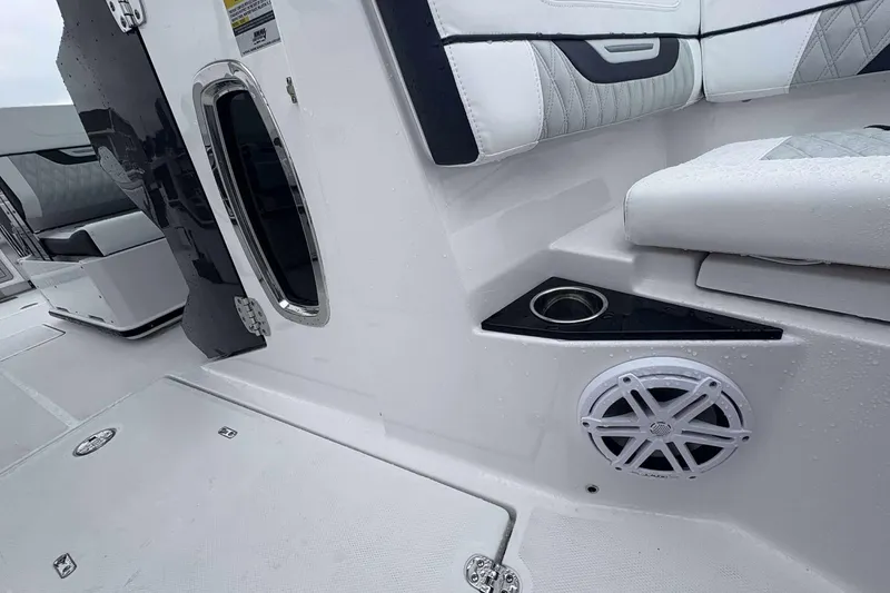 Slide: The Image of 2025 Blackfin 252 DC boat interior with white seating, cup holder, and speaker. - 14