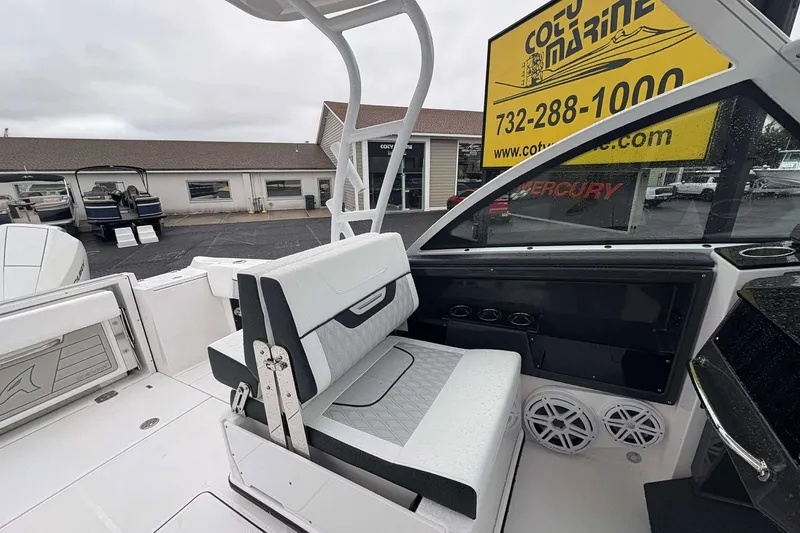 Slide: The Image of 2025 Blackfin 252 DC boat interior with seating and dashboard, displayed at a marine dealership. - 20
