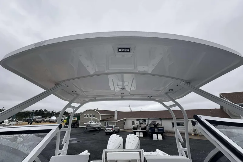 Slide: The Image of 2025 Blackfin 252 DC boat with sleek hardtop design, parked in a marina. - 4
