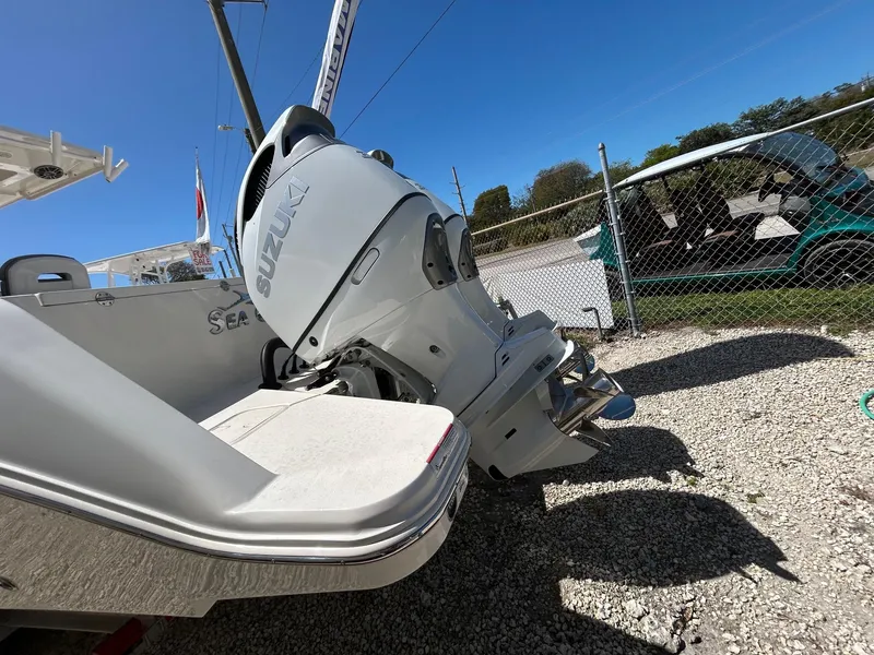 Slide: The Image of 2024 Streamline Ace boat with Suzuki outboard motor, parked on gravel near a fence. - 4