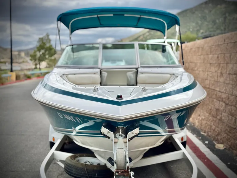 Slide: The Image of 1994 Cobalt 222 boat on trailer, teal and white, parked outdoors. - 2