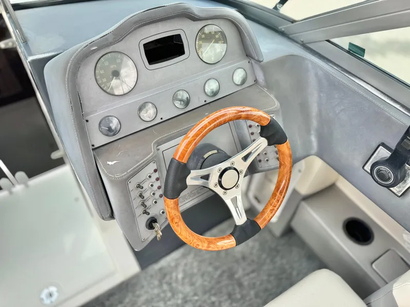 Slide: The Image of 1994 Cobalt 222 boat dashboard with wood-accented steering wheel and classic instrument panel. - 24
