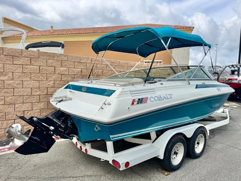 Slide: The Image of 1994 Cobalt 222 boat with blue canopy on a trailer, parked outdoors. - 5