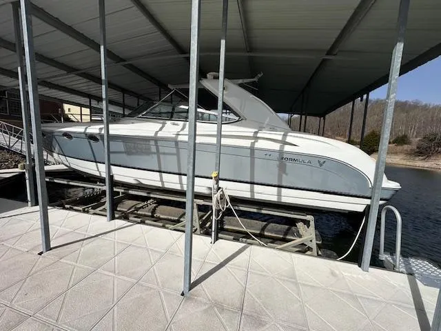 Slide: The Image of 2004 Formula 400 Super Sport boat docked under a covered marina. - 0